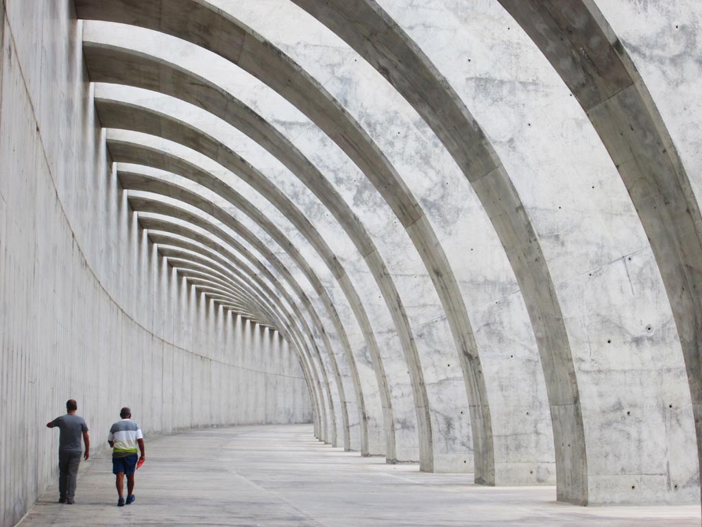 Dos turistas pasean el dique que atrae las vistas