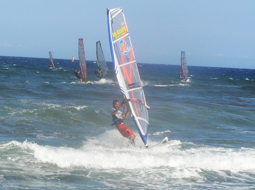 Windsurfistas se desplazan sobre el agua con sus tablas y velasmanejadaptan fuertes f