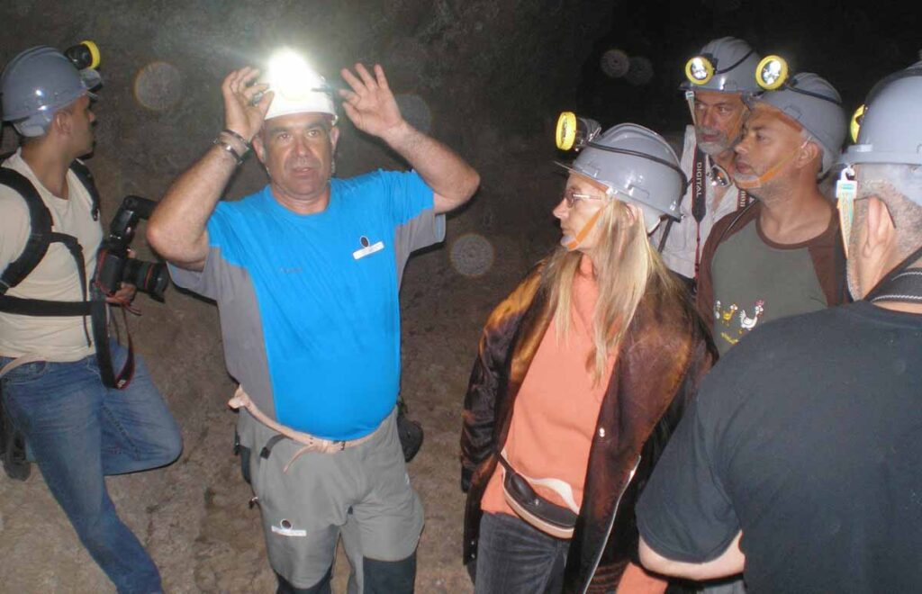 El guía y un grupo de visitantes en las profundidades de la Cueva del Viento