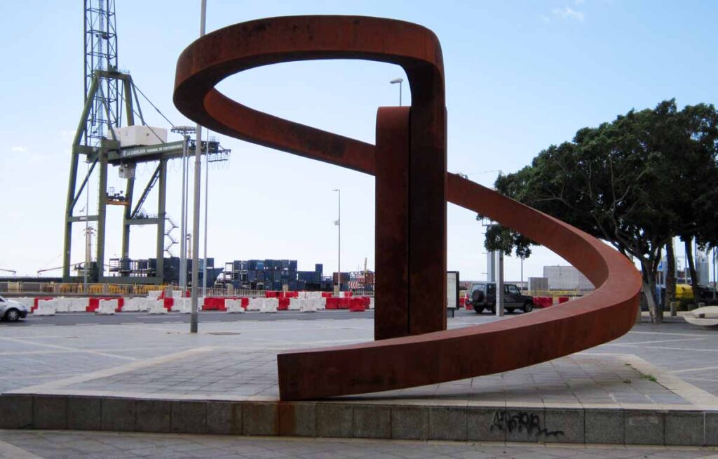 La escultura de Chirino en primer plano y una grúa del puerto en el fondo