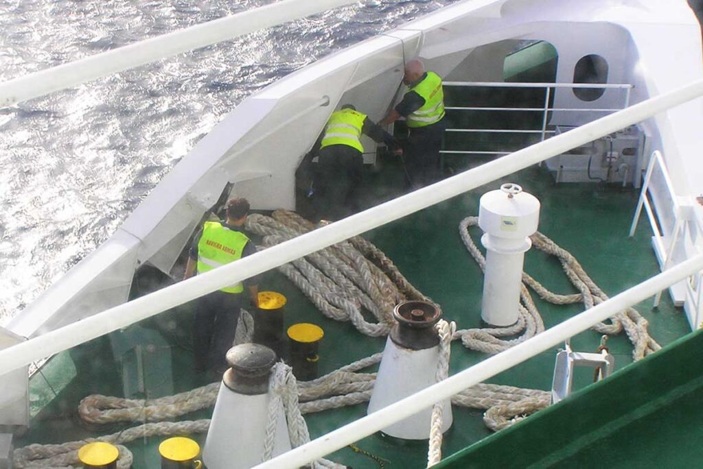 Algunos marineros preparan las amarras para el atraco del ferry 