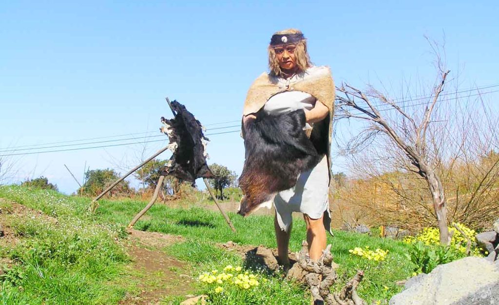 Muñeco guanche que manipula una pieza de cuero