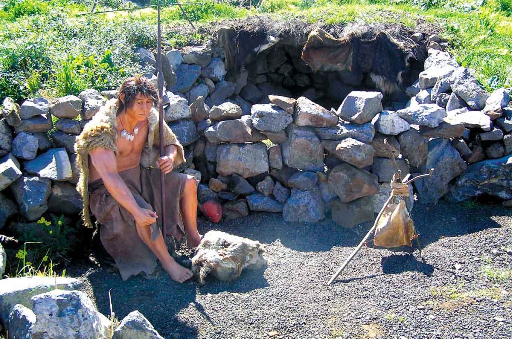 Un muñeco guanche sentado delante de su residencia