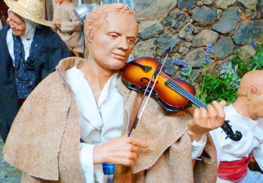 Figura de violinista, colocada en un tradicional entorno canario