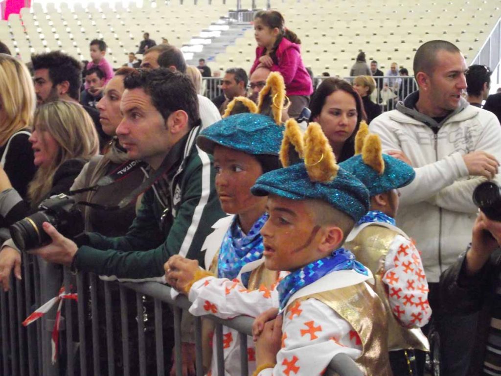 Dos jóvenes carnavaleros observan la actuación de los competidores