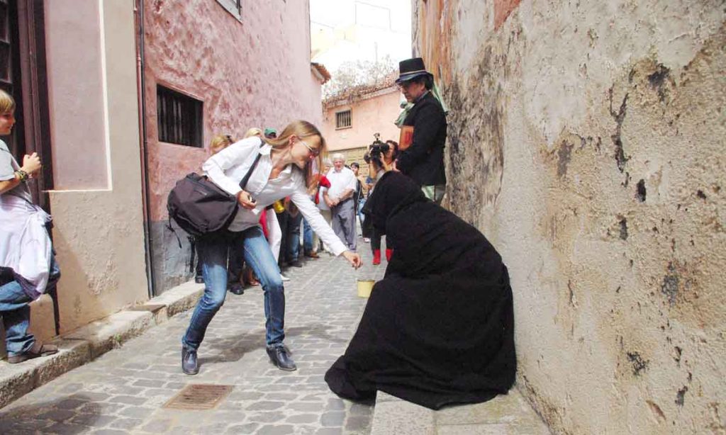 Los turistas pasan por mendigos de anteriores épocas