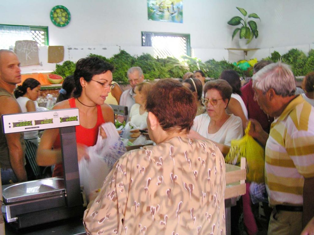 Clientes se abastecen en una frutería del mercado