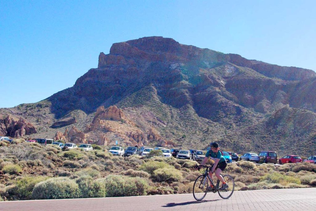 Un ciclista pasa por el aparcamiento al lado del Roque García